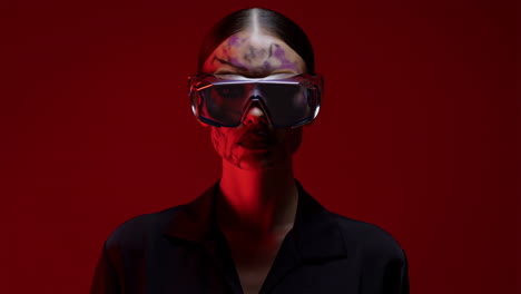 futuristic portrait of woman in goggles with red light