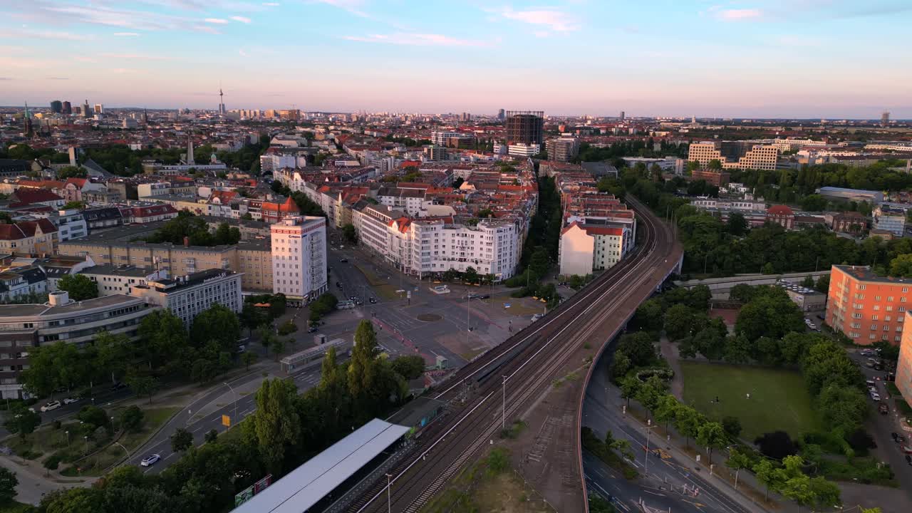 Panoramic Aerial View of a European Cityscape with Railway Tracks at Sunset