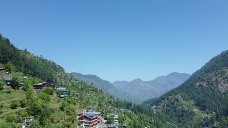 aerial view short of jibhi himachal pradesh in india. houses and trees in the mountainous area. faguli festival is one of the biggest festival in jibhi. the traditional houses here have stone roofs.