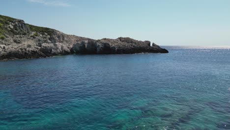 Vista-Aérea-De-La-Costa-Rocosa-Y-Agua-Azul-Clara