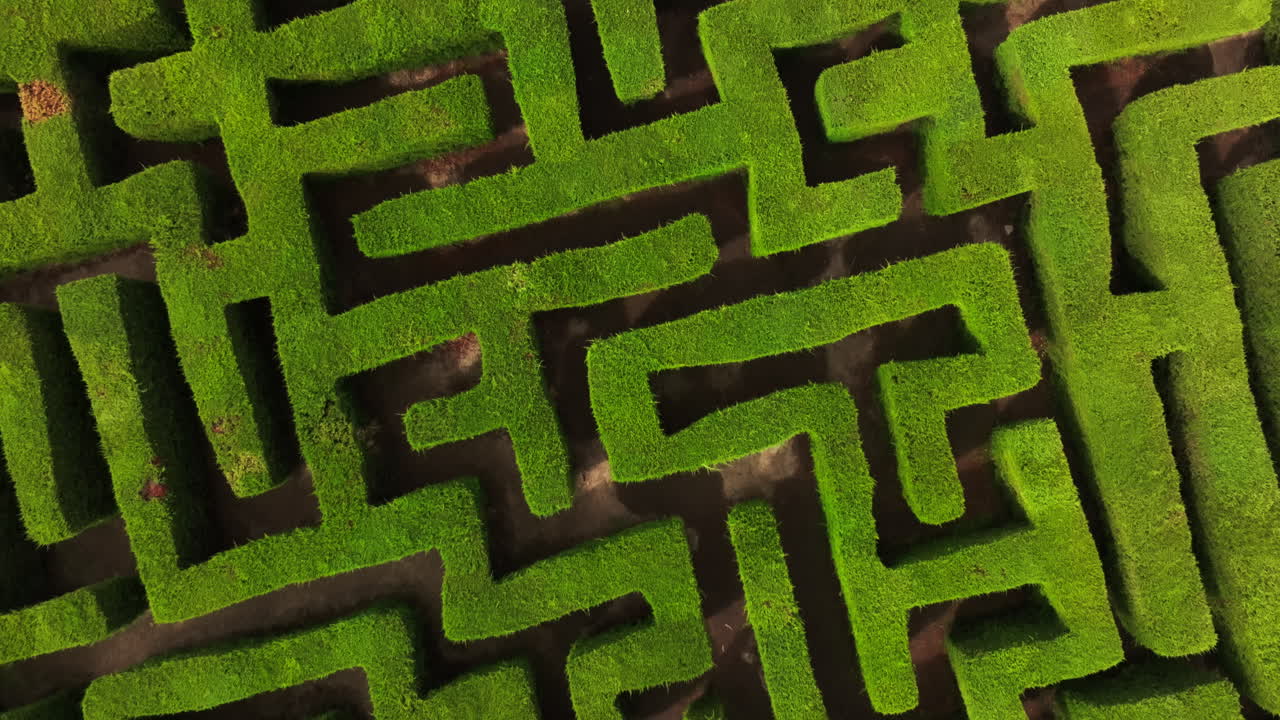 Drone flying over a square garden labyrinth, overhead geometric landscape