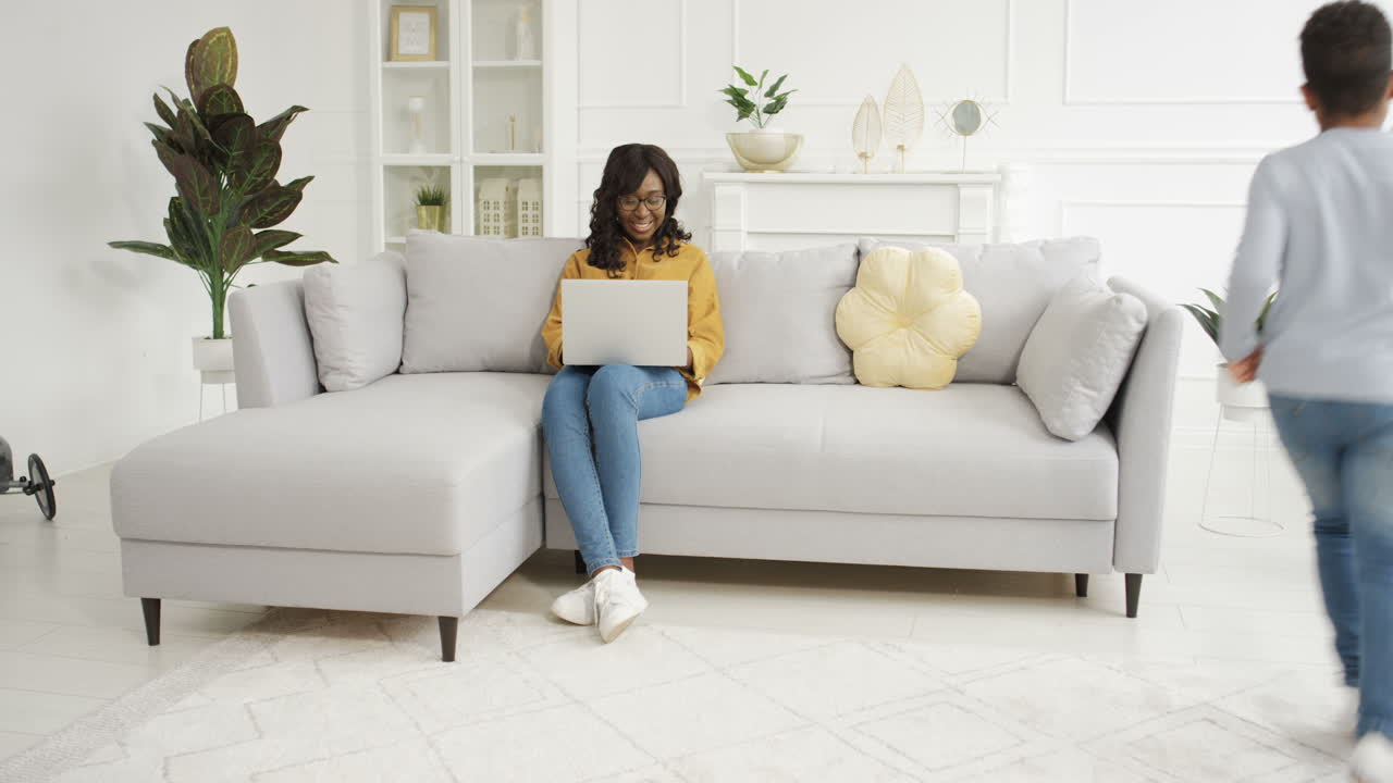 dos niños alegres corriendo en círculos y rondas en la sala de estar
