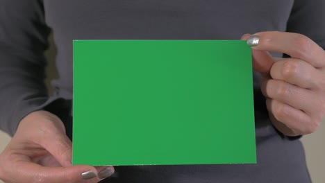 woman holding green paper for green screen editing 4k 2160p ultrahd footage - female holding greenscreen editing background 4k 3840x2160 uhd video