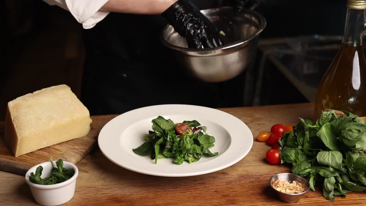 Chef Plating Fresh Salad with Greens and Cherry Tomatoes
