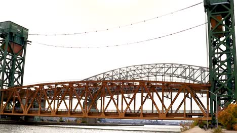a lift bridge descends to its lowest level, with cyclists traversing the pier