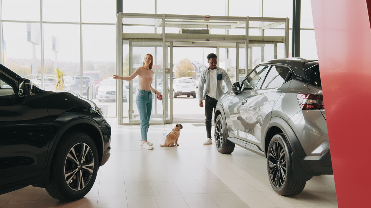 개 와 함께 대리점 에서 자동차 를 보고 있는 부부