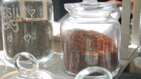 variedad de tés de hojas sueltas en frascos de vidrio