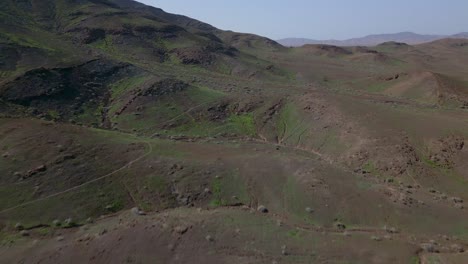 Aerial-jib-up-over-rolling-hills-revealing-small-Spanish-town-in-the-distance