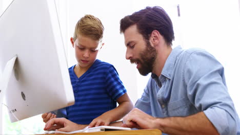 father and son using computer together