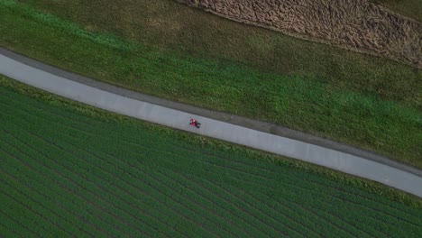 drone footage of a woman riding a fitness bike tricycle filmed from above