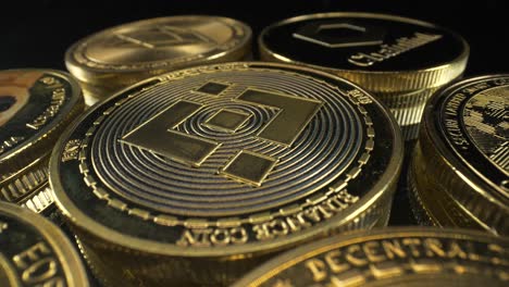 Goldene-Binance-Bnb-münze-Auf-Einem-Haufen-Kryptomünzen,-Die-Sich-Auf-Schwarzem-Hintergrund-Drehen,-Kryptomarkt,-4k-rotationsaufnahme