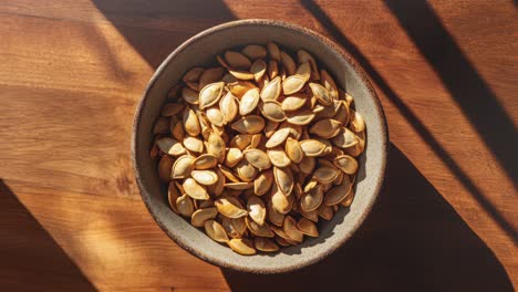 Top-View-of-Pumpkin-Seeds-in-a-Bowl-on-Wooden-Surface