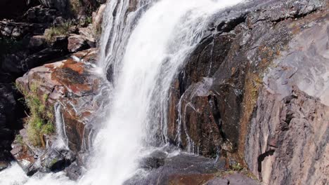 toma aérea de drones que recorre la cascada y muestra una cascada de volumen gigante con rocas secas en primer plano