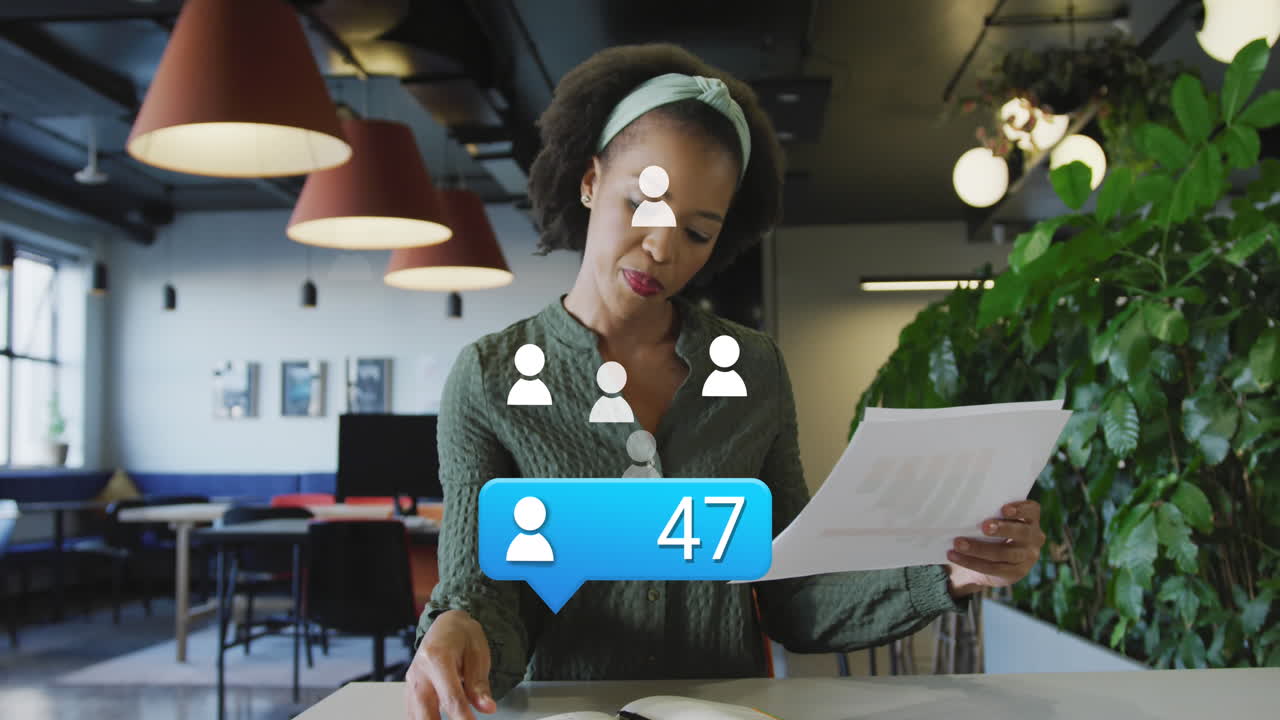 Animation of profile icon floating over african american woman reading documents at office