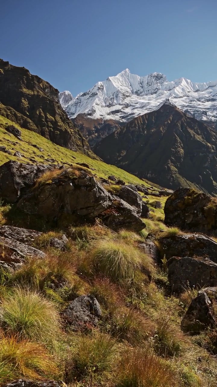 Vertical Rugged Rocky Mountains Landscape in Nepal, Big Dramatic Snowcapped Annapurna Mountain Tops and Peaks in Himalayas Mountain Scenery on Blue Sky Sunny Day in High Altitude Terrain