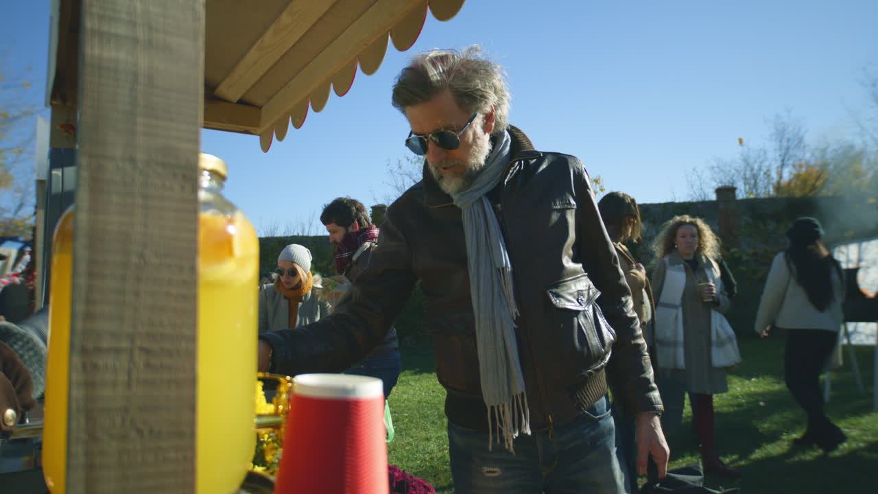 Senior Man Buys Products at Farmers Market Senior Man at the Stall Chooses and Buys Fruits and Vegetables People Walking and Shopping on Background Local Farmers Market or Fair Outdoors Vegetarian and Organic Food Agriculture
