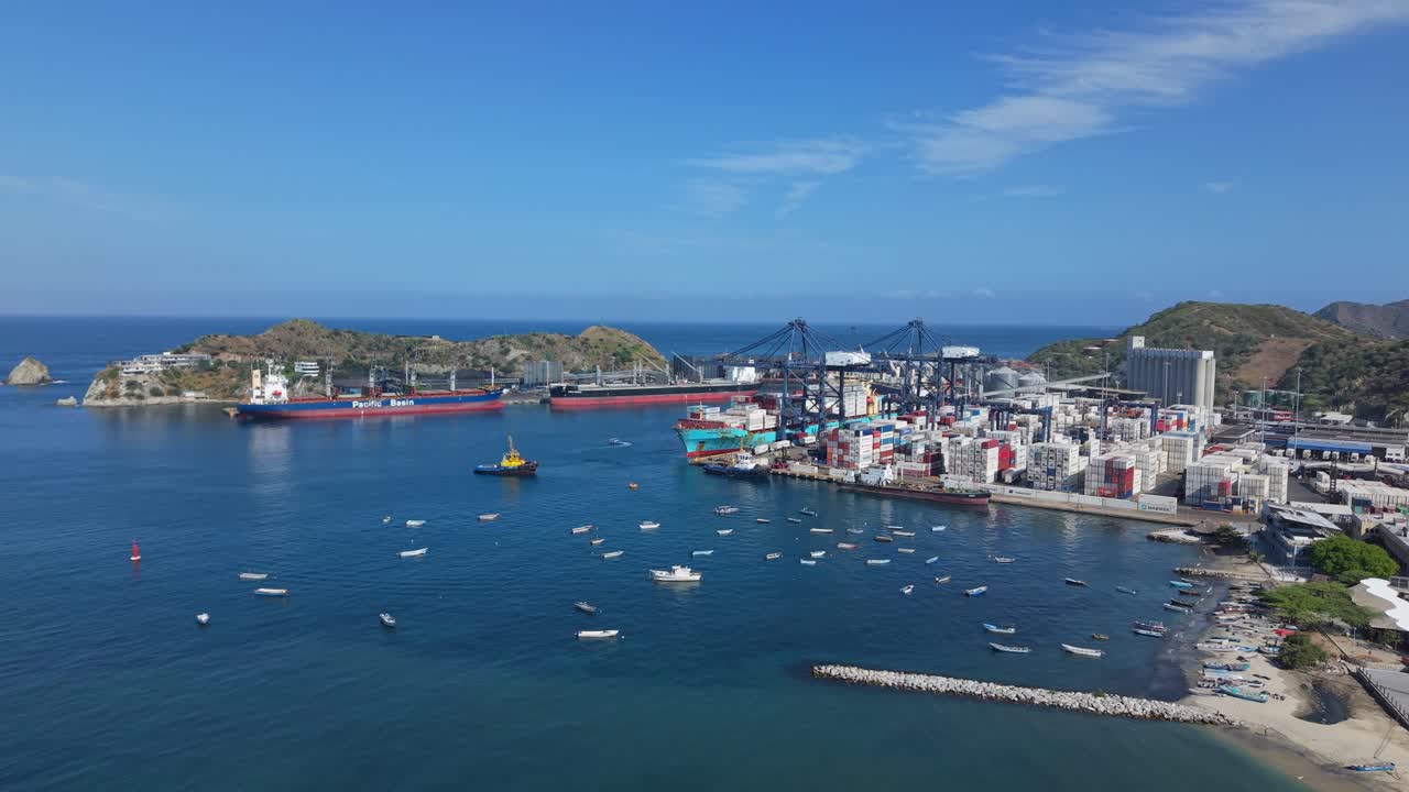 Città portuale costiera di Santa Marta con barche e industria sotto cieli soleggiati.