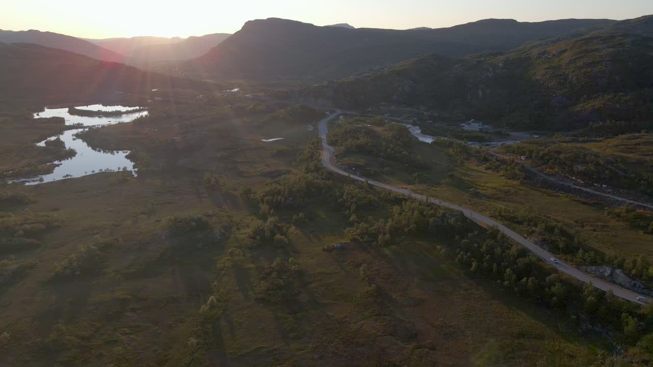 Scenic drive along road on plateau, aerial view during golden hour