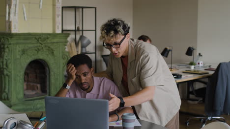 colleagues collaborating and offering support in a modern office