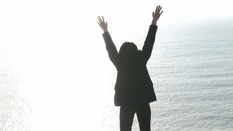 woman on a cliff worshipping