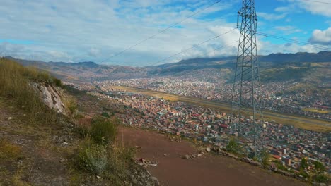 reveal shot of cusco airport runway, city, and mountains under a sunny sky, peru.
