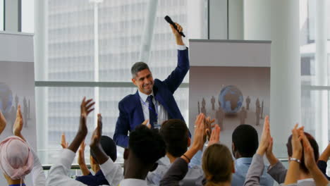 Animation-of-network-of-connections-with-icons-over-diverse-colleagues-at-meeting-clapping-hands