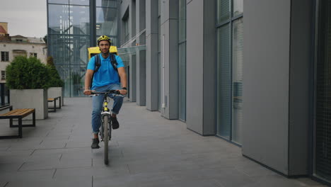 delivery person on bicycle near modern office building