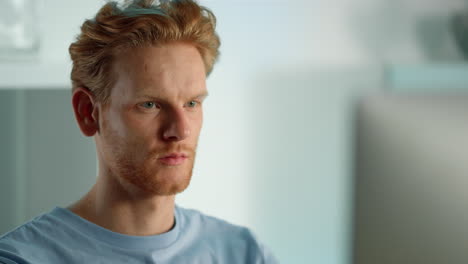 Closeup-focused-developer-working-at-home-office.-Serious-ginger-man-browsing
