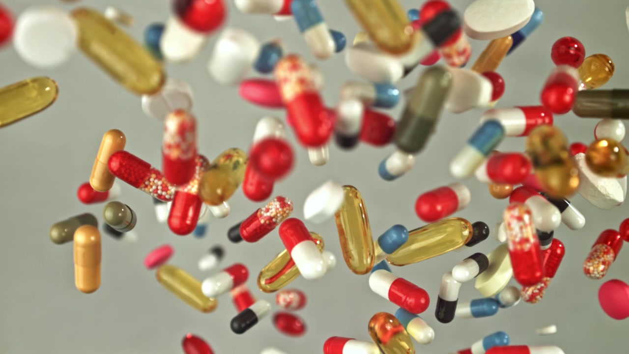 Colorful Pills and Capsules Falling in Slow Motion