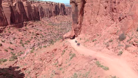 Los-Vehículos-En-La-Carretera-Del-Cañón-Deben-Conducir-Bajo-Una-Enorme-Caída-De-Roca-Arenisca