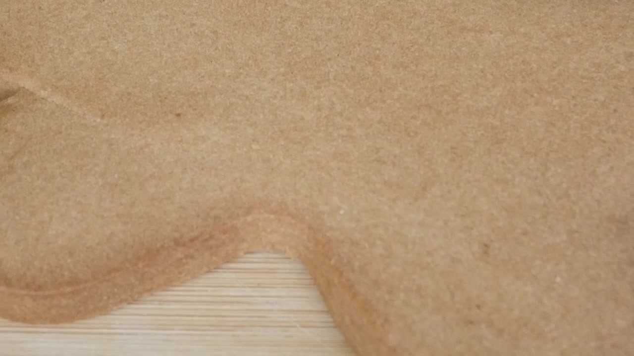 Klar til å dekorere stor pepperkake på trefjøl. Noen ingredienser og sesongbaserte dekorasjoner rundt.