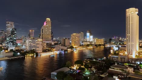 Toma-De-Lapso-De-Tiempo-De-Barcos-De-Crucero-En-El-Río-Chao-Phraya-En-Bangkok-Con-El-Horizonte-Por-La-Noche