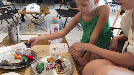 child and parent decorating halloween cookies