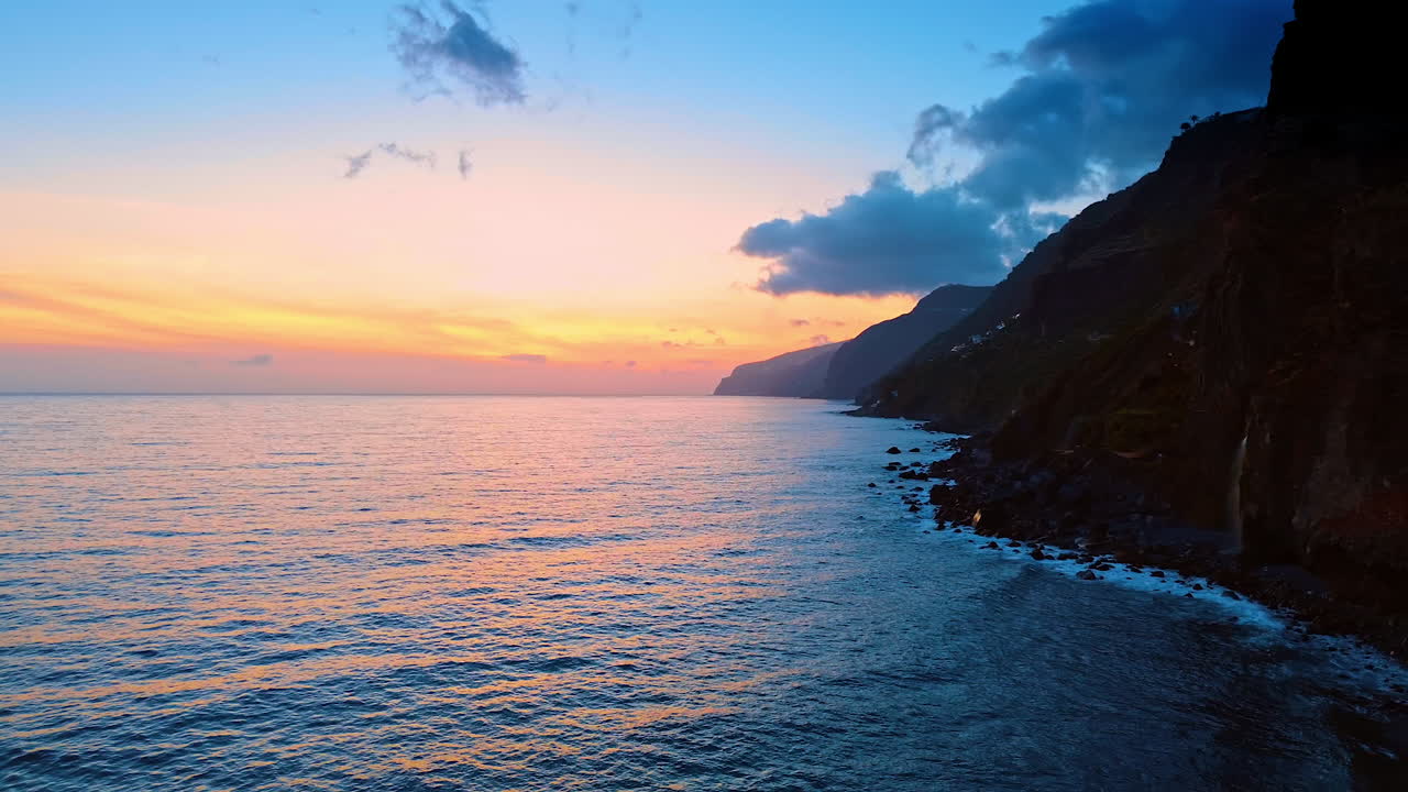 The Atlantic Ocean at the rocky coast of the Madeira Islands, Portugal. Drone footage above the waterscape at sunset time.