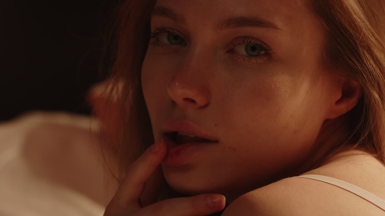 Sensual portrait of a beautiful woman with stunning blue eyes looking at the camera in slow motion