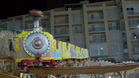 children riding on train roller coaster in outdoor funfair