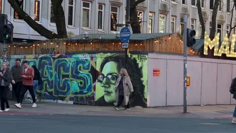 urban street scene with people and large street art mural