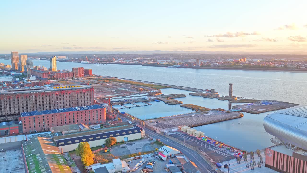 Aerial drone footage of the area surrounding Bramley-Moore Dock in Liverpool, UK, filmed at sunset. This golden-hour footage captures residential streets, local housing, docklands, the River Mersey