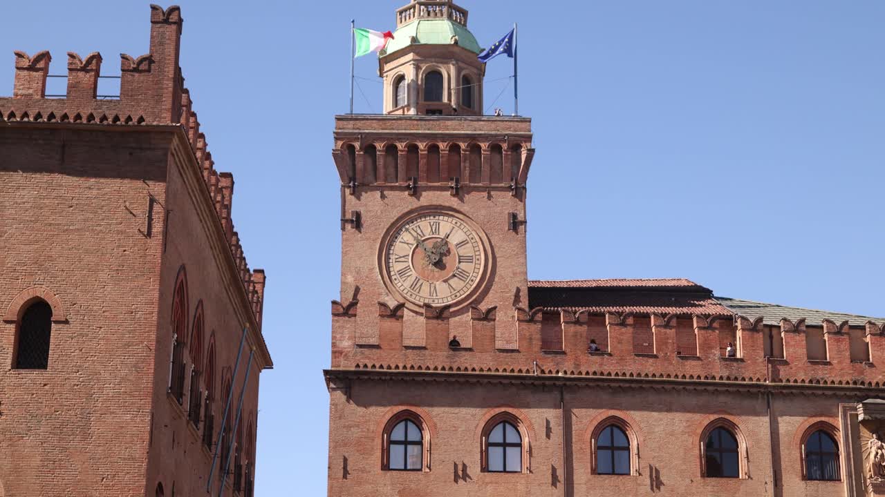 Close-up of Palazzo d'Accursio clocktower under a clear sky, Bologna, Italy