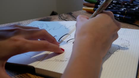 woman writes in a calligraphy style in her travel journal