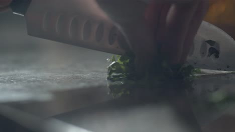 Pizza-maker-cutting-parsley-in-kitchen