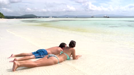 the couple is in the water near the sea