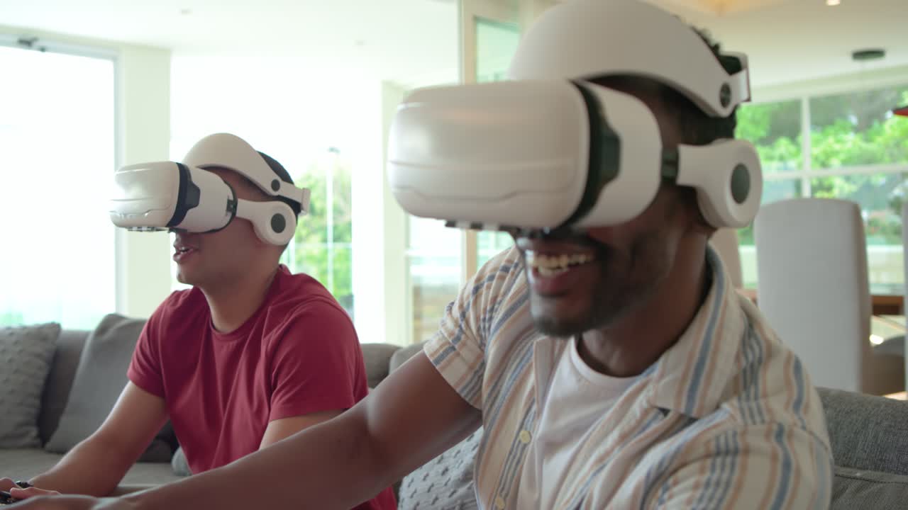 Diversi amici indossano visori VR, inclinano la testa e si protendono sul divano in soggiorno