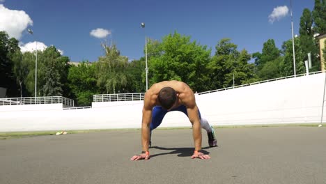 man performing jumping jacks outdoors