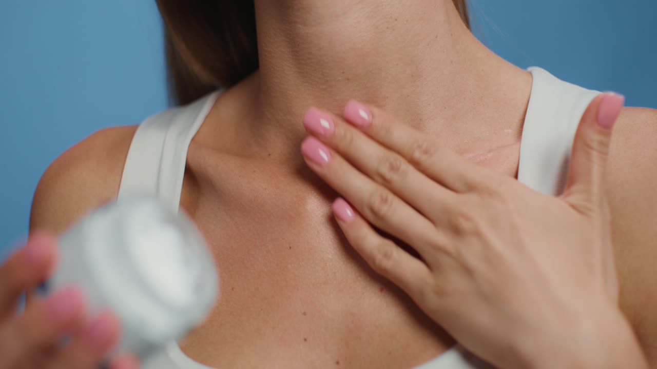 Donna che applica crema su collo e décolleté