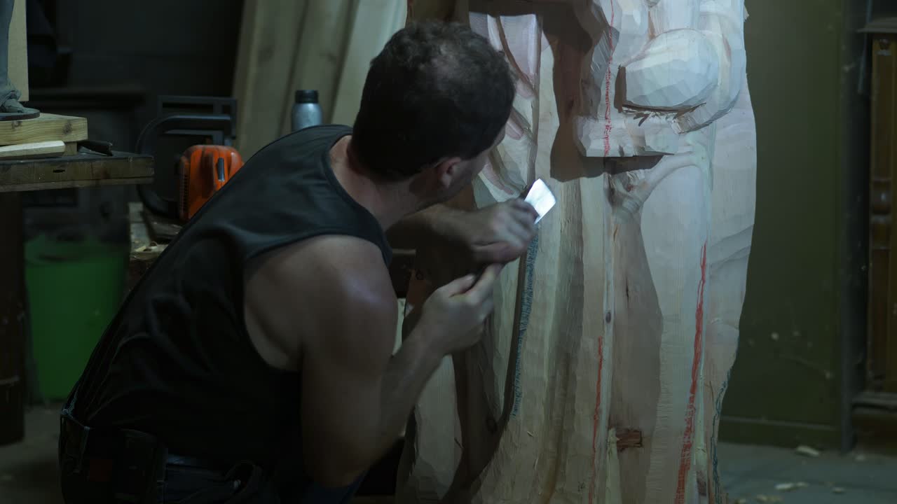 Skilled italian adult fit artisan carefully carving wooden Madonna sculpture, meticulously shaping intricate details with traditional manual tool in refined slow-motion woodworking process