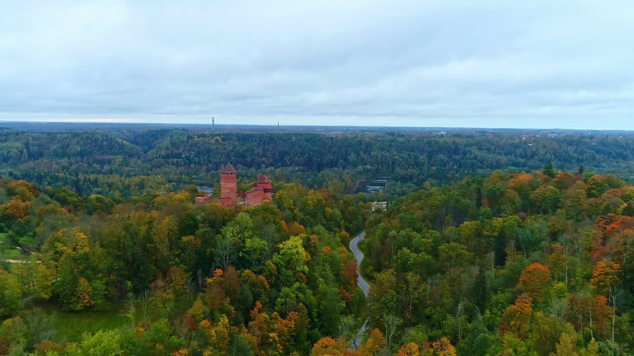 vista aérea del castillo de turaida rodeado por el bosque de otoño en letonia