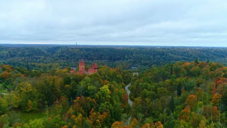 Aerial-View-of-Turaida-Castle-Surrounded-by-Autumn-Forest-in-Latvia