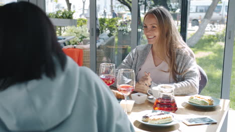 friends celebrating a baby shower in a cafe