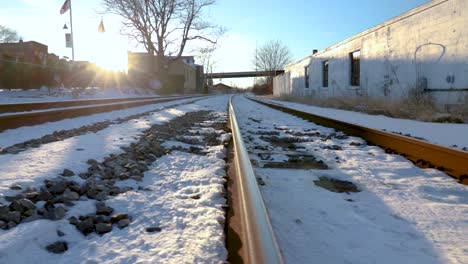 panorámica horizontal baja al suelo sobre un cruce ferroviario en una pequeña ciudad urbana